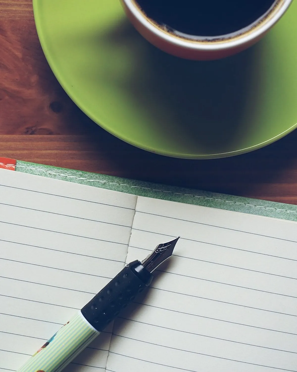 Un bureau avec un carnet ouvert et un stylo plume