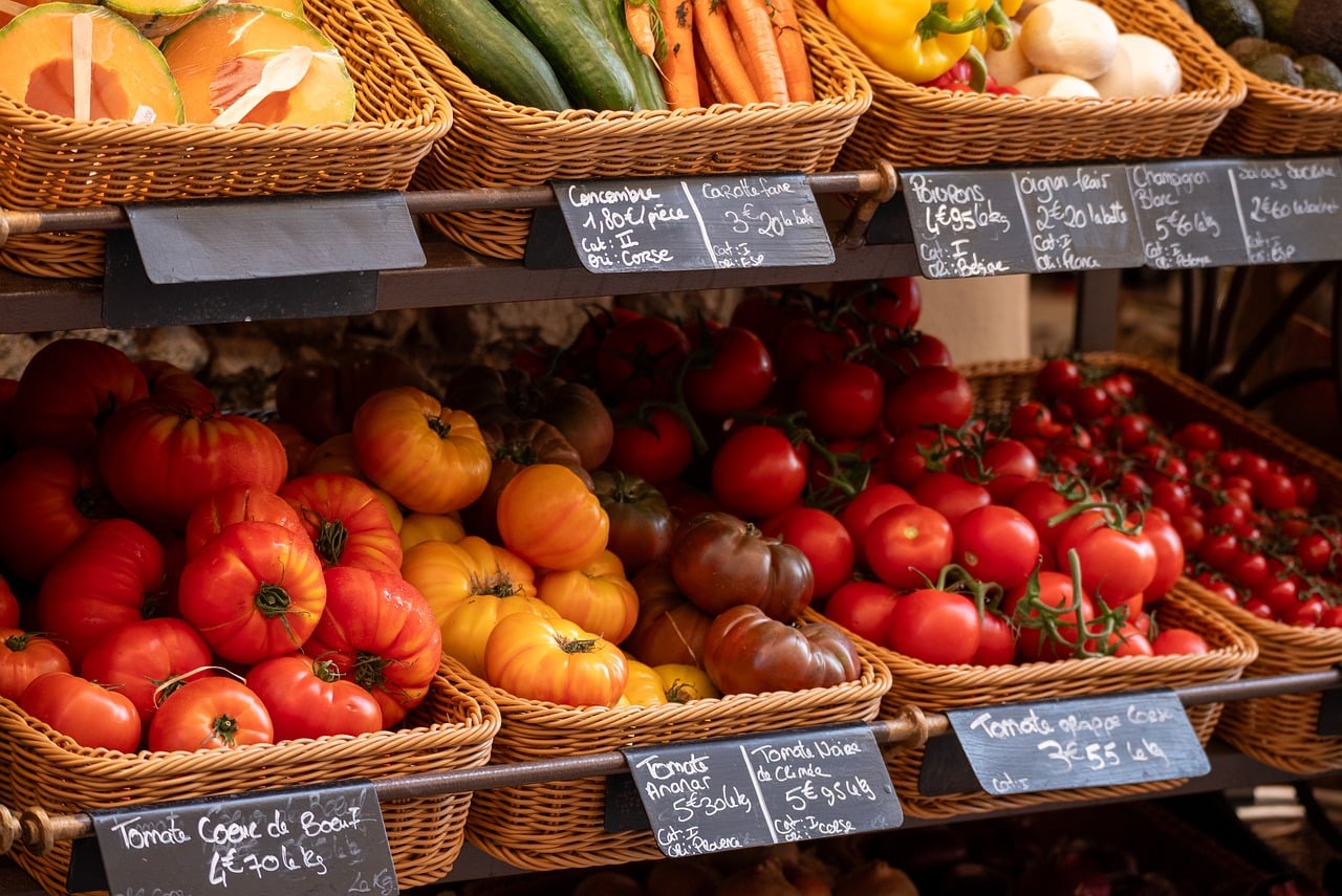Étal de marché provençal avec légumes colorés et étiquettes de prix en français