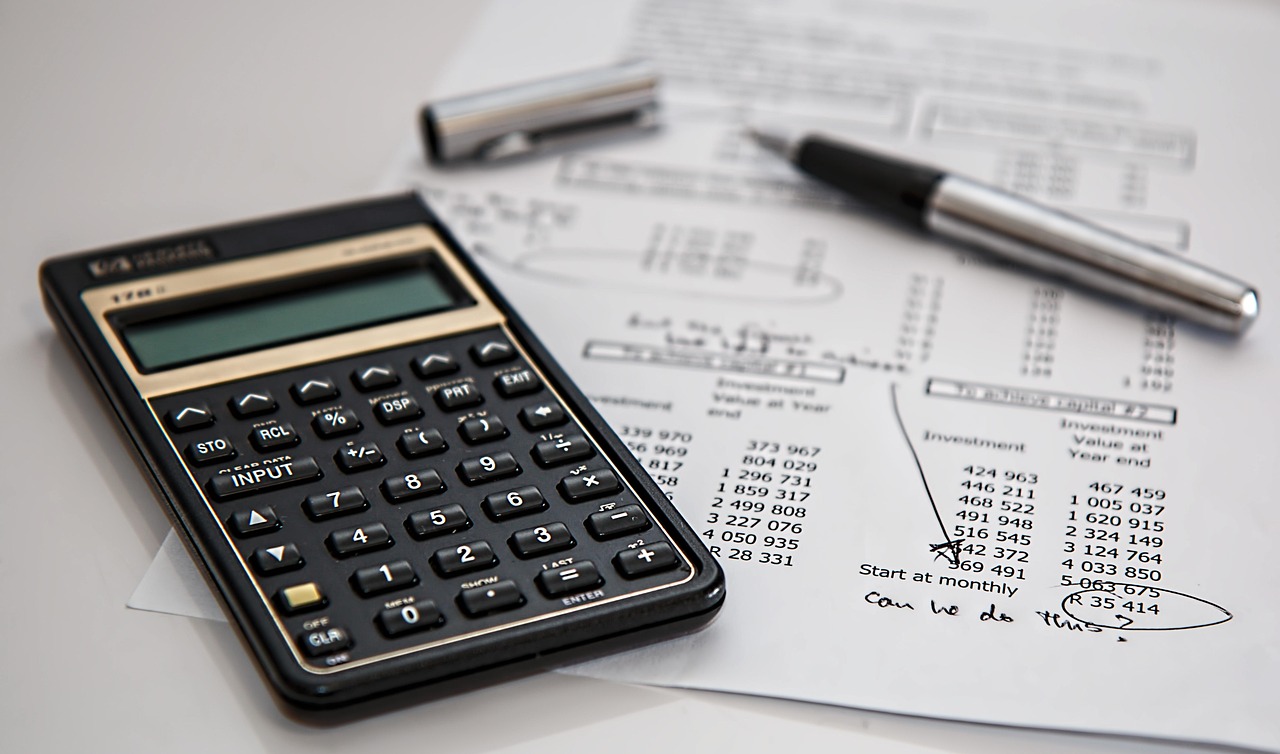 Calculatrice, documents et stylo pour la planification financiere