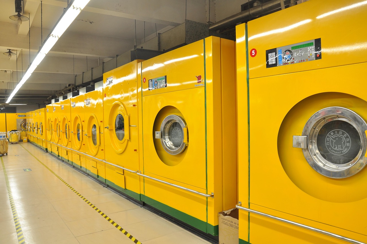 Rangee de machines a laver jaunes dans une laverie
