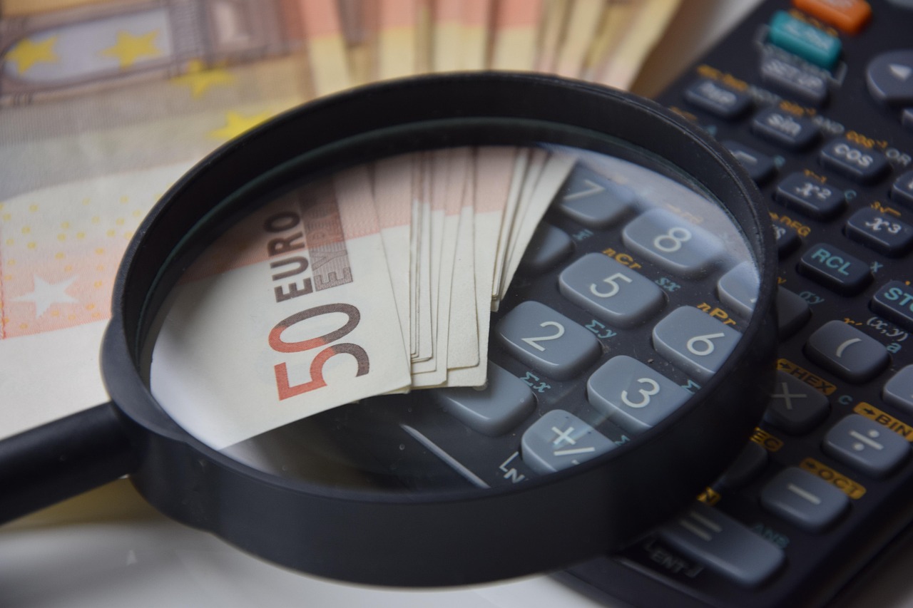 Loupe posee sur des billets en euros a cote d'une calculatrice