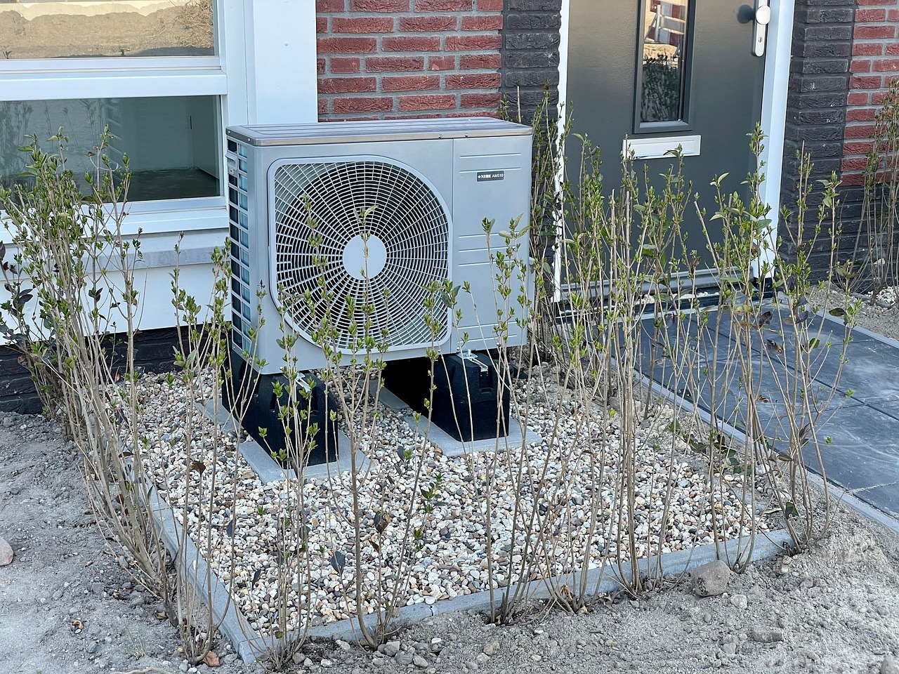 Unite exterieure de pompe a chaleur installee pres d'une maison