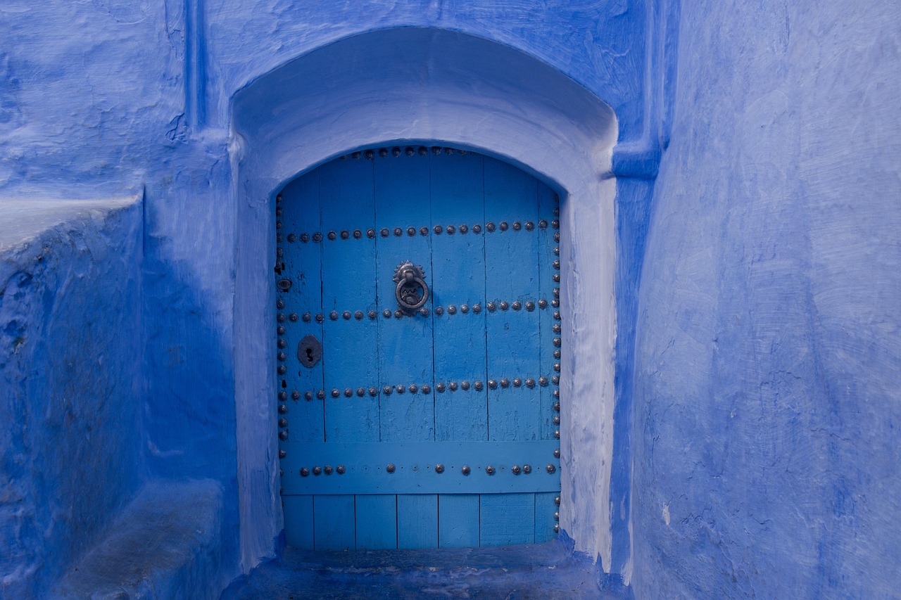 Porte d'entree bleue ornee dans un mur blanc