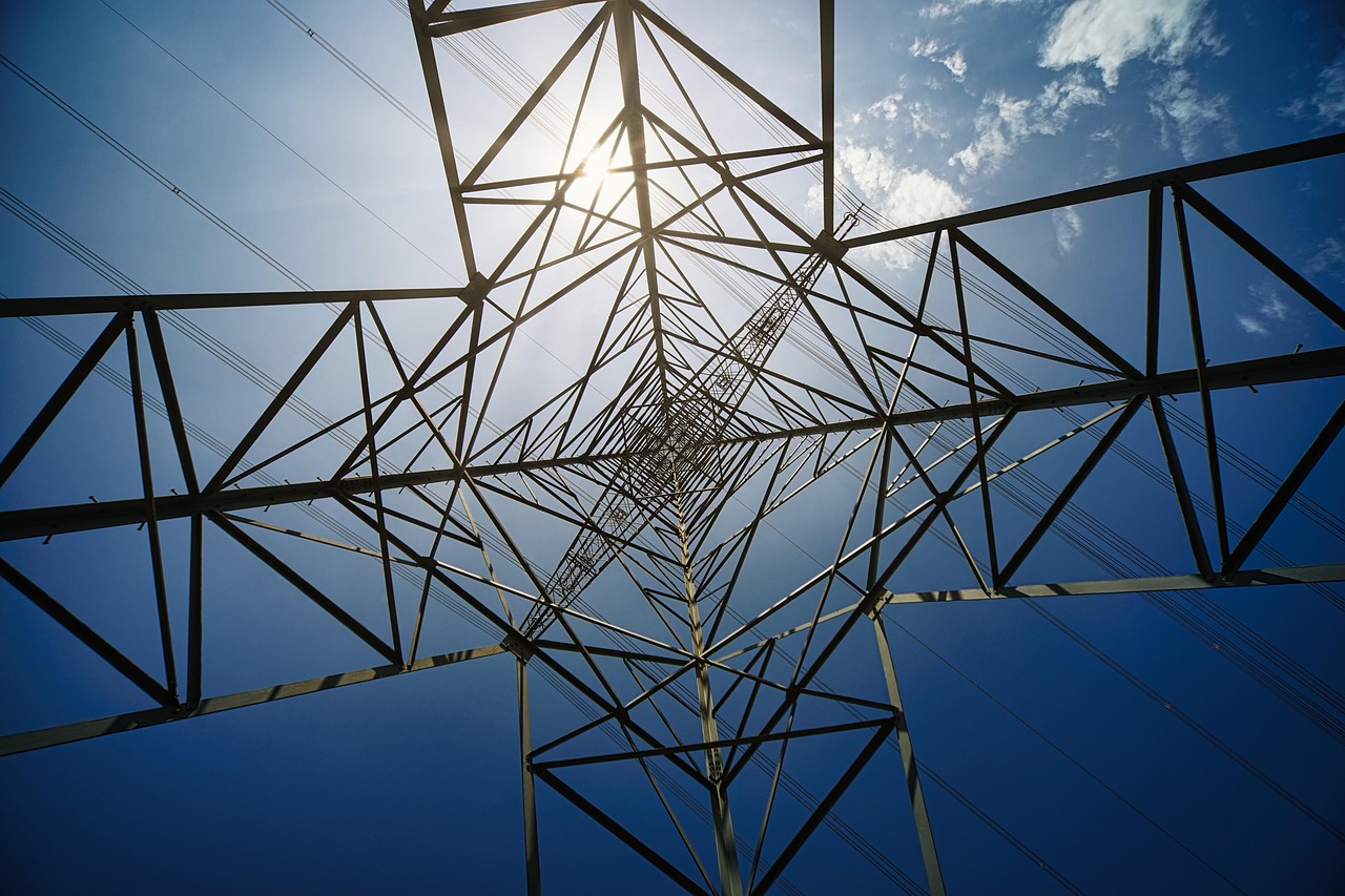 Pylône à haute tension vu en contre-plongée sous un ciel bleu