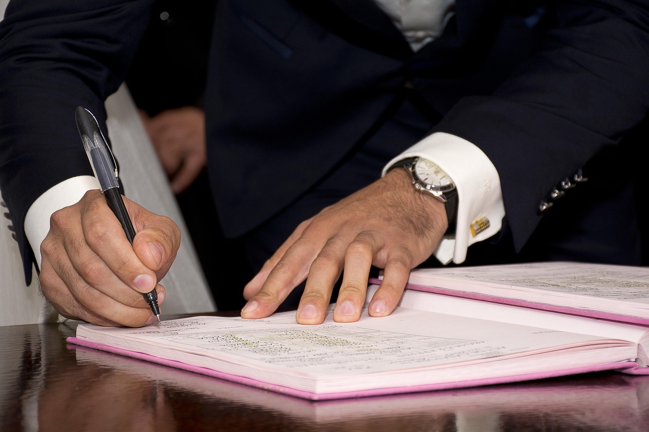 Main qui signe un contrat avec un stylo, gros plan