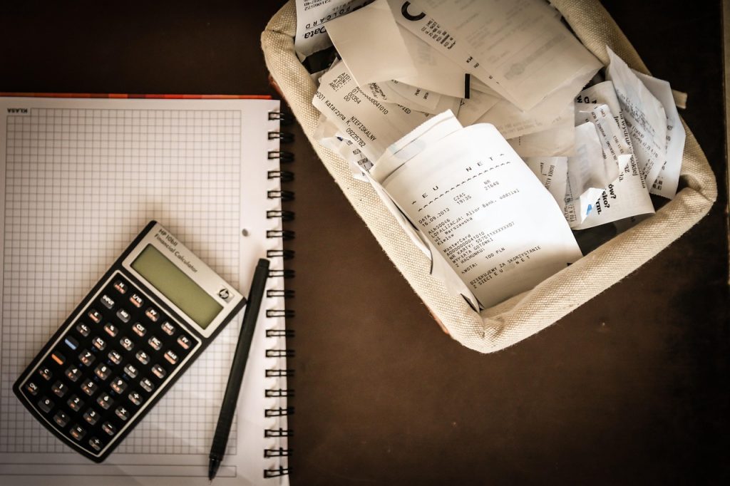 Calculatrice posée sur une pile de tickets de caisse