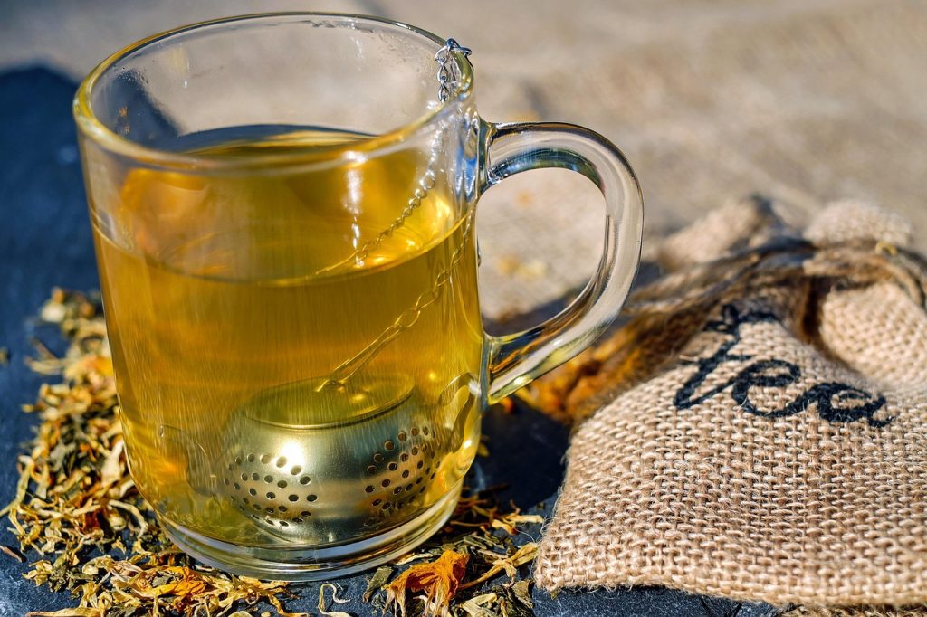 Verre de thé fumant avec des feuilles de thé