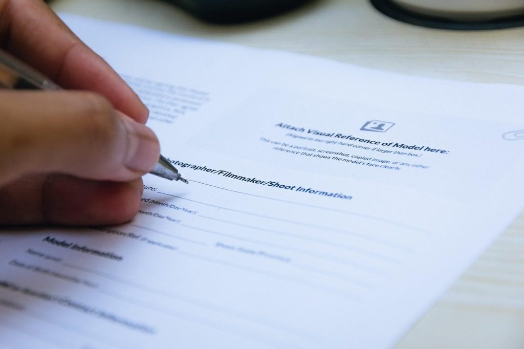 Main qui signe un document officiel sur un bureau