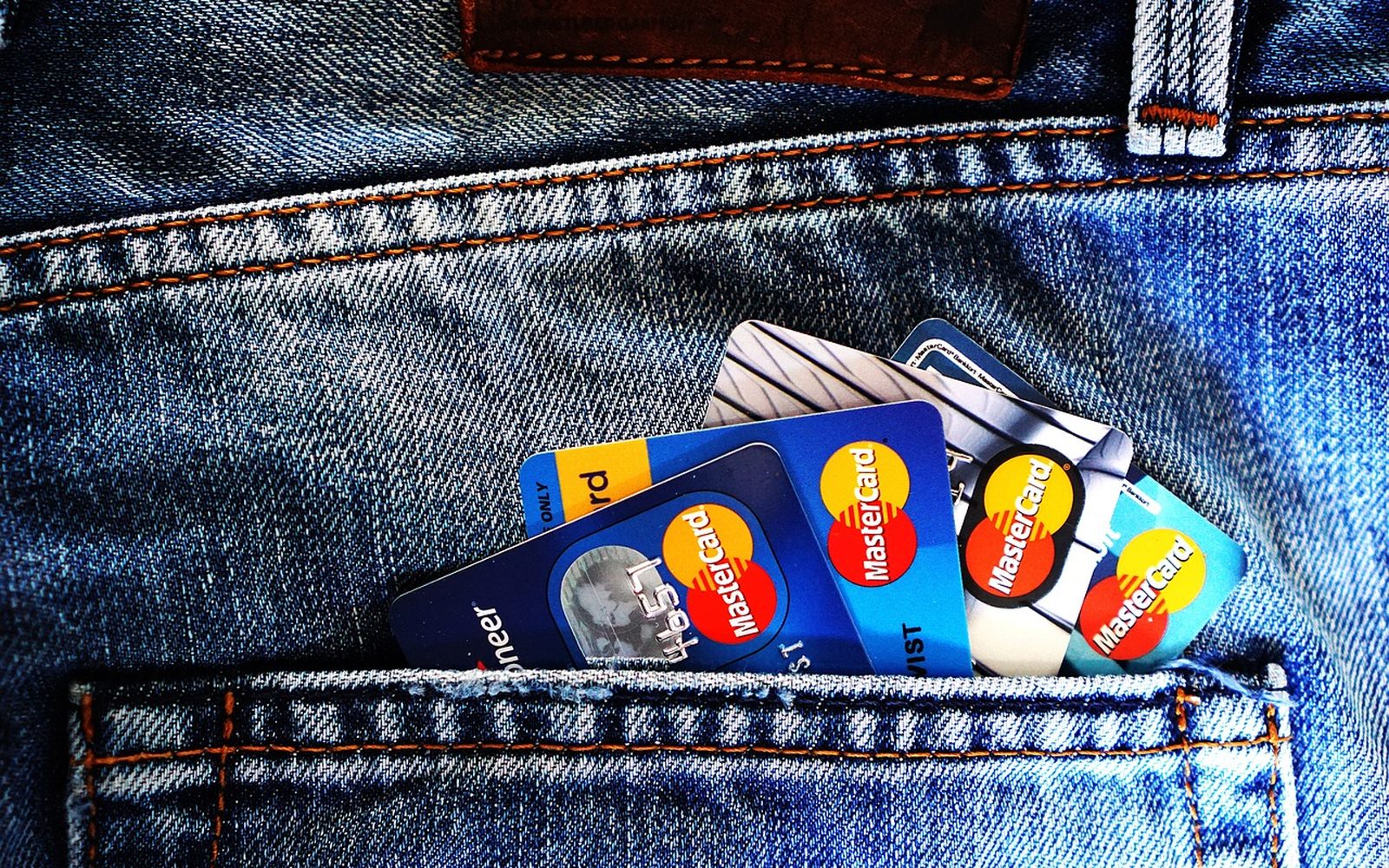 Plusieurs cartes bancaires rangées dans un portefeuille en jean