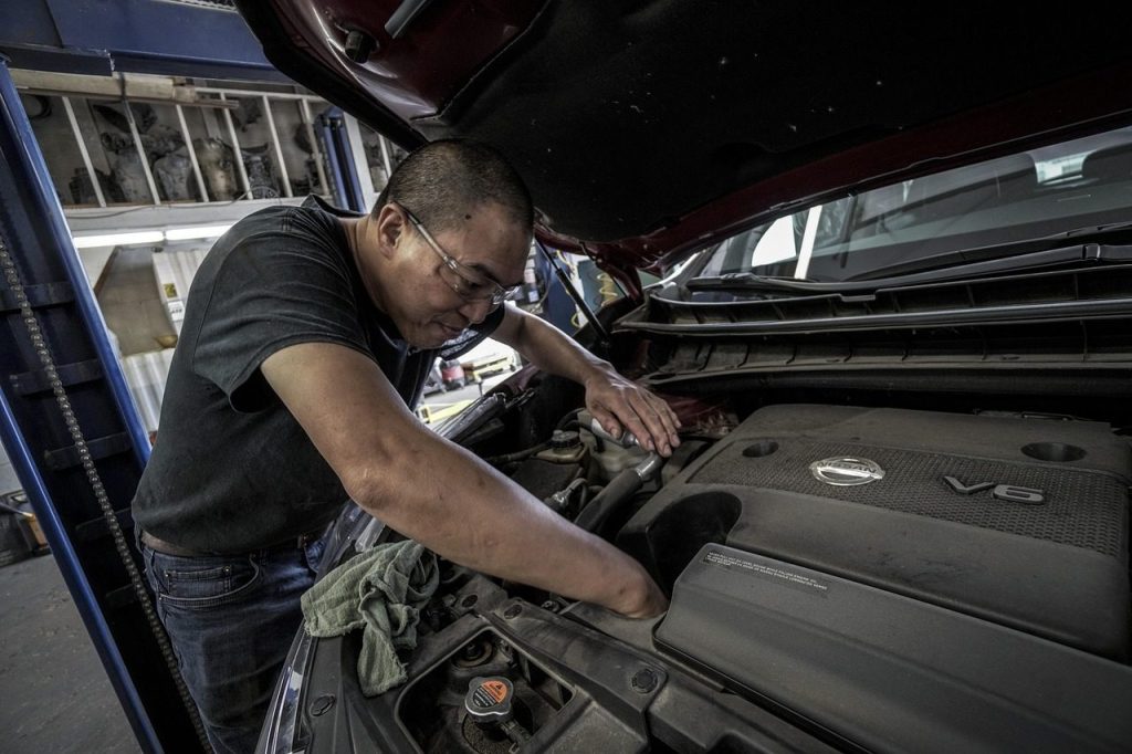 Capot ouvert d'une voiture dans un garage, moteur visible pour un entretien