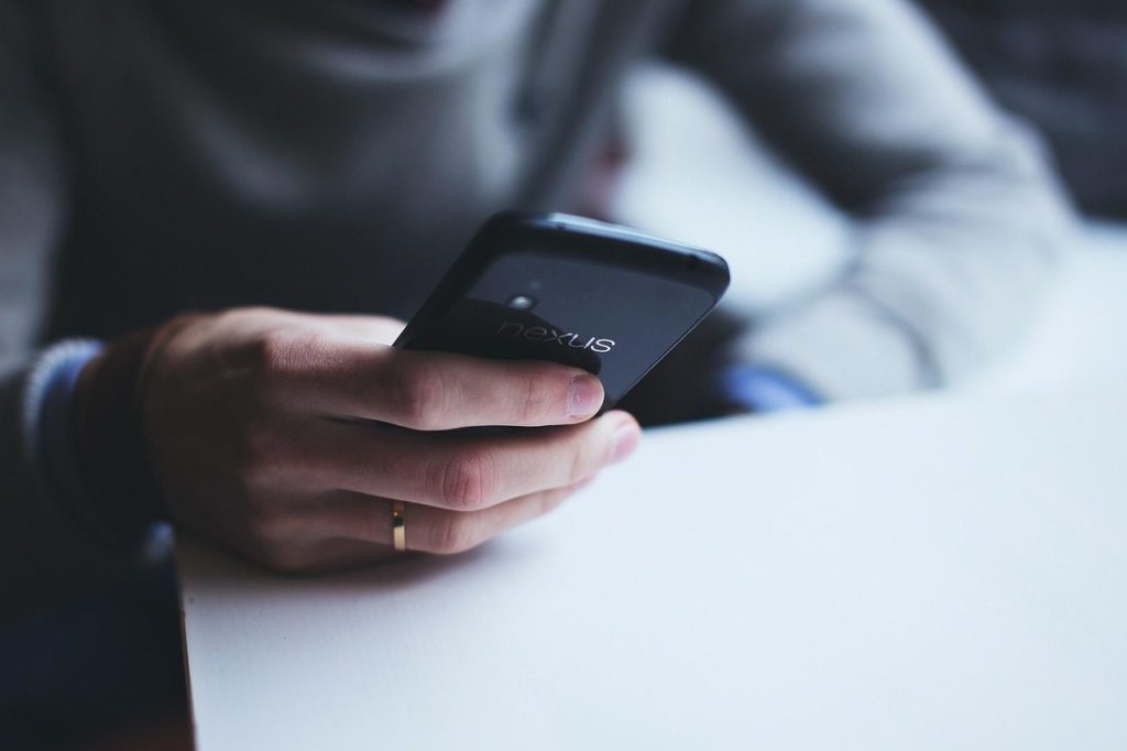Main qui tient un smartphone et touche l'écran