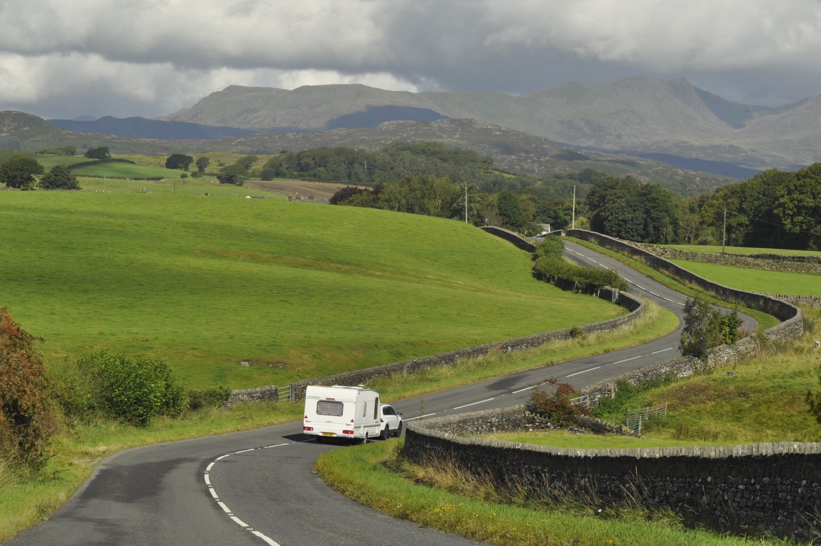 Voiture tractant une caravane sur une route de campagne