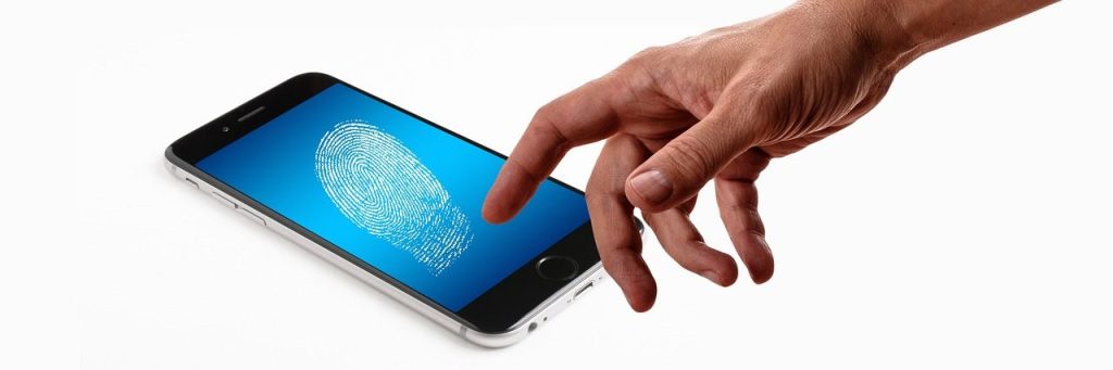 Main qui pose le doigt sur l'écran d'un smartphone affichant une icône d'empreinte digitale