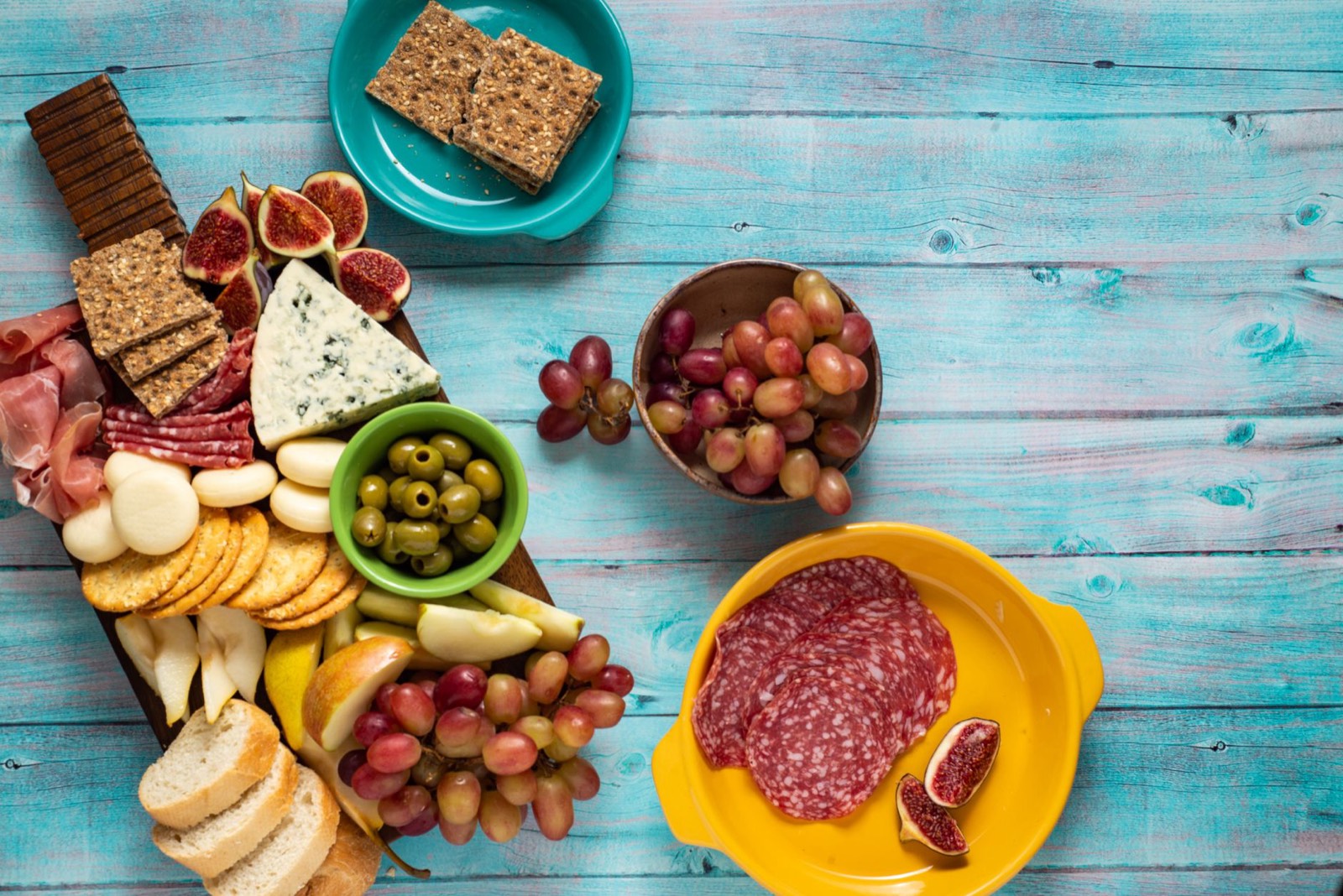 Planche d'apéritif faite maison posée sur une table en bois pour une soirée entre amis