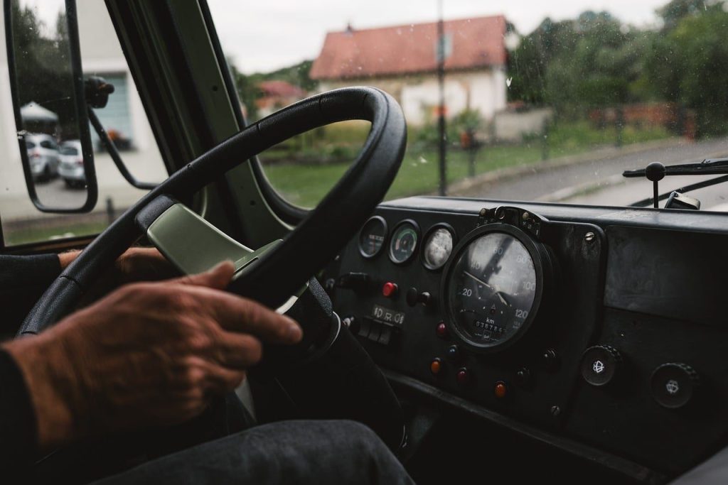 Main d'un conducteur sur le volant avec le tableau de bord et le compteur de vitesse en arrière-plan