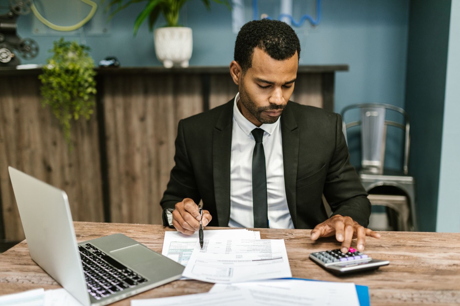 Dirigeant analysant des documents financiers sur son ordinateur avant la vente de sa société